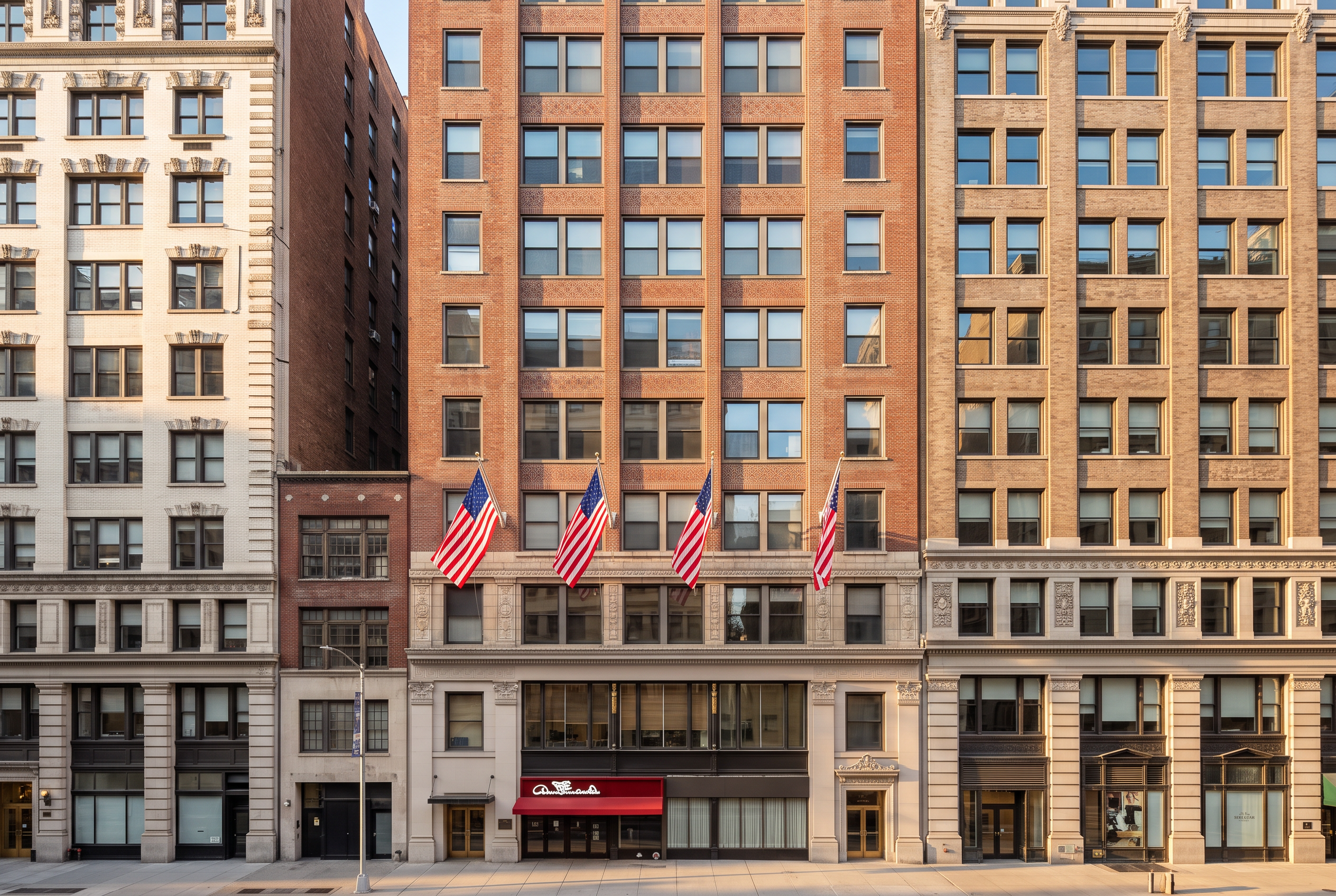 Facade of 35 West 35th Street, a prewar Manhattan office building with American flags above the entrance